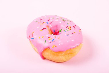 Pastele arka plan üzerinde pembe yuvarlak çörek. Düz yatıyordu, en iyi görünümü.