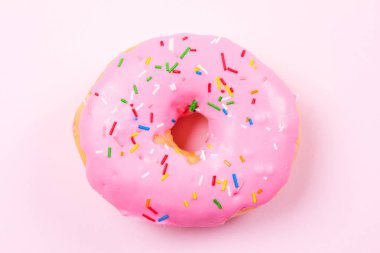 Pastele arka plan üzerinde pembe yuvarlak çörek. Düz yatıyordu, en iyi görünümü.