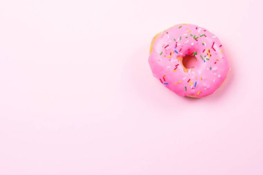 Pastele arka plan üzerinde pembe yuvarlak çörek. Düz yatıyordu, en iyi görünümü.