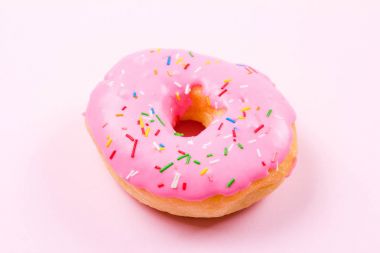 Pastele arka plan üzerinde pembe yuvarlak çörek. Düz yatıyordu, en iyi görünümü.
