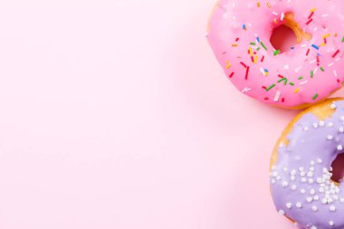 Pastele arka plan üzerinde pembe yuvarlak çörek. Düz yatıyordu, en iyi görünümü.