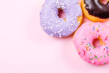 Pastele arka plan üzerinde pembe yuvarlak çörek. Düz yatıyordu, en iyi görünümü.