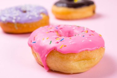 Pastele arka plan üzerinde pembe yuvarlak çörek. Portre