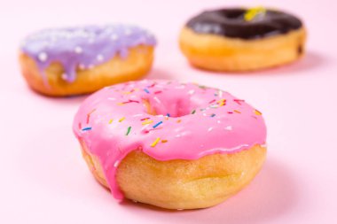 Pastele arka plan üzerinde pembe yuvarlak çörek. Portre