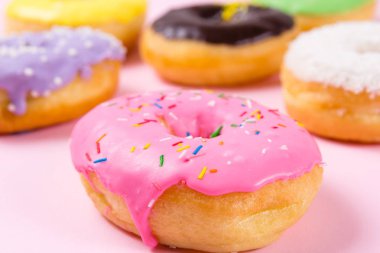 Pastele arka plan üzerinde pembe yuvarlak çörek. Portre