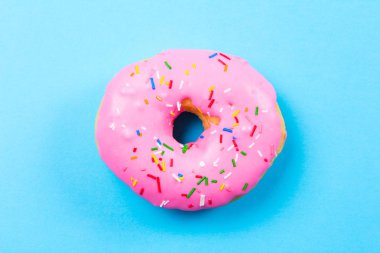 Mavi arka plan üzerinde pembe yuvarlak çörek. Düz yatıyordu, en iyi görünümü.