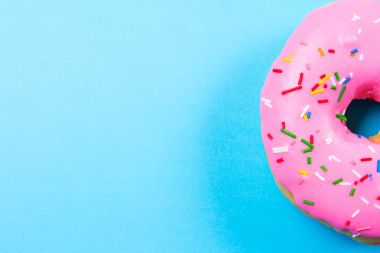 Mavi arka plan üzerinde pembe yuvarlak çörek. Düz yatıyordu, en iyi görünümü.