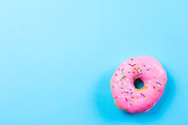 Mavi arka plan üzerinde pembe yuvarlak çörek. Düz yatıyordu, en iyi görünümü.