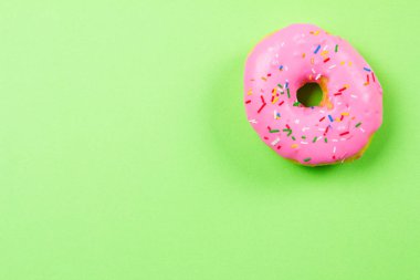 Yeşil zemin üzerine pembe yuvarlak çörek. Düz yatıyordu, en iyi görünümü.