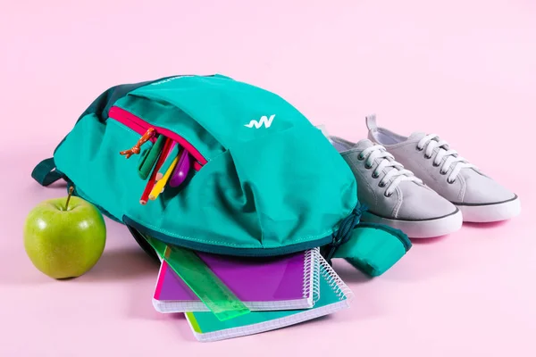 Mochila com papelaria escolar em fundo rosa — Fotografia de Stock