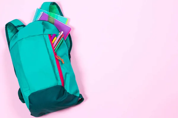 Mochila com papelaria escolar em fundo rosa — Fotografia de Stock