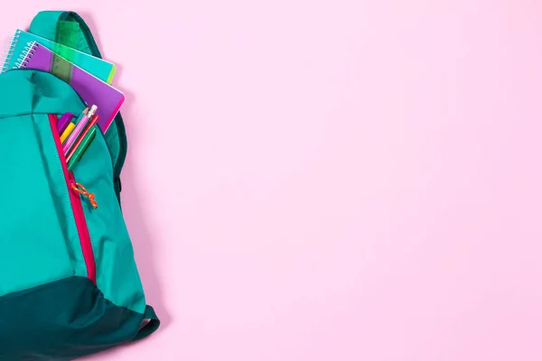 Mochila com papelaria escolar em fundo rosa — Fotografia de Stock