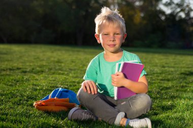 Kitap ve bir sırt çantası ile sevimli okul çocuğu