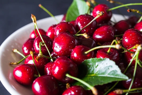 Cerezas frescas rojas maduras en plato blanco — Foto de Stock