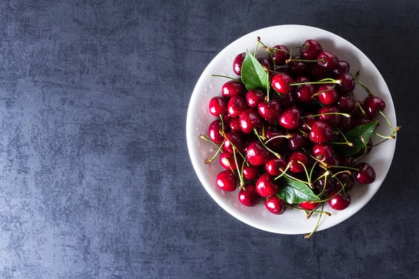 Свежие красные спелые вишни на белой тарелке — стоковое фото