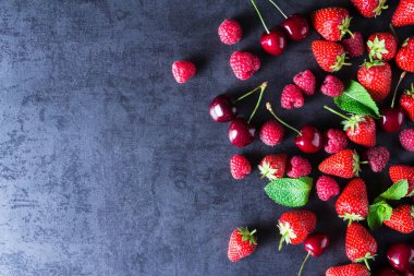 Taze kırmızı olgun meyveleri koyu gri masada