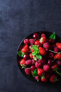 Taze kırmızı olgun meyveler siyah plaka üzerinde