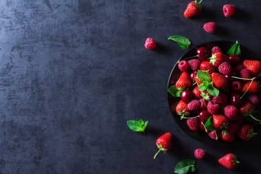 Taze kırmızı olgun meyveler siyah plaka üzerinde