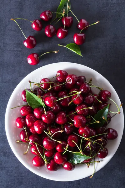 Cerezas frescas rojas maduras en plato blanco — Foto de Stock