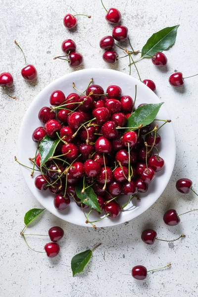 Cerezas frescas rojas maduras en plato blanco — Foto de Stock