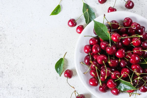 Cerezas frescas rojas maduras en plato blanco — Foto de Stock