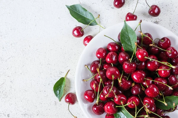 Cerezas frescas rojas maduras en plato blanco — Foto de Stock