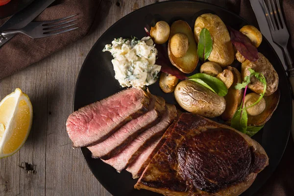 Biefstuk en bijgerecht van gebakken aardappelen en champignons — Stockfoto