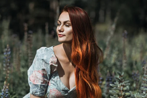 Bir çiçek alanda güzel bir kızıl saçlı kız portresi