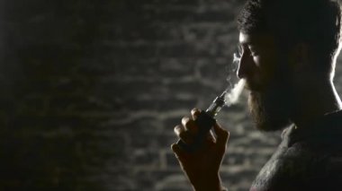 Sakal vaping elektronik sigara olan genç adam. Vaper hipster duman Buharlaştırıcı yavaş hareket 