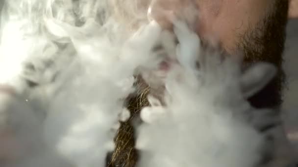 Young man with beard vaping an electronic cigarette. Vaper hipster smoke vaporizer in slow motion — Stock Video