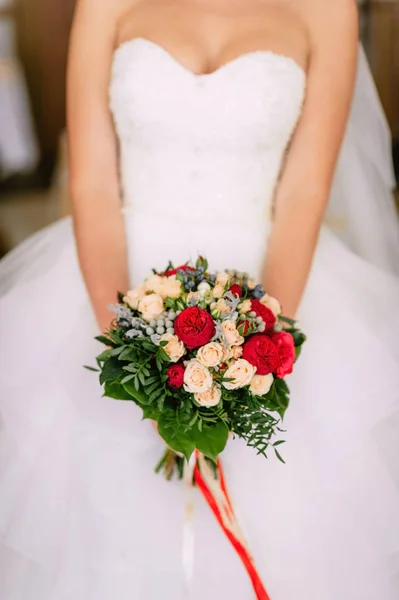 The bride holding a red bouquet. wedding flowers. soft focus. — Stock Photo, Image