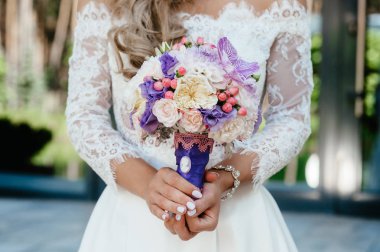 mor bir buket tutan gelin. düğün çiçekleri. yumuşak odak.