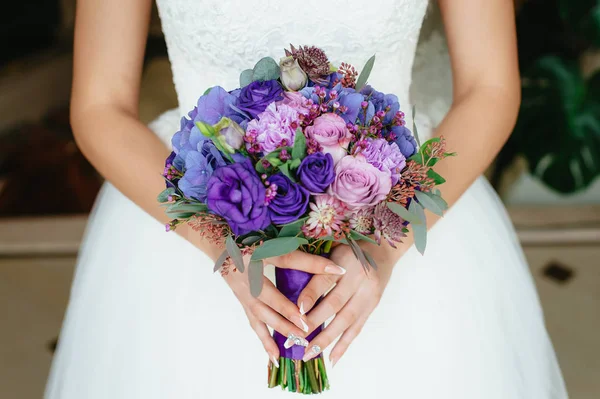 A noiva segurando um buquê roxo. flores do casamento. foco suave . — Fotografia de Stock