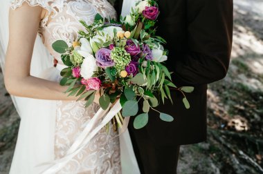 Gelin ve damat bir buket tutarak. düğün çiçekleri