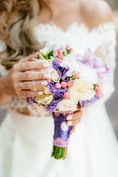 A noiva segurando um buquê roxo. flores do casamento. foco suave . — Fotografia de Stock