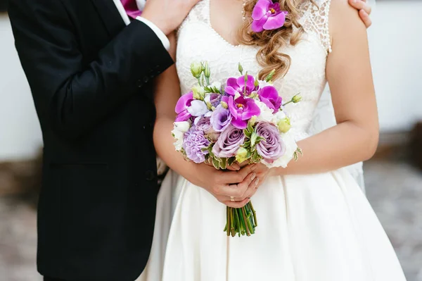 Bride and groom holding a bouquet. wedding flowers — Stock Photo, Image
