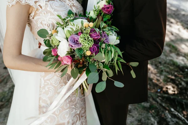 新娘和新郎抱着一束。婚礼鲜花 — 图库照片