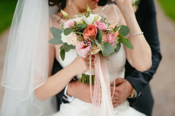 Bride and groom holding a bouquet. wedding flowers — Stock Photo, Image