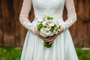 bir buket tutan gelin. düğün çiçekleri. yumuşak odak.