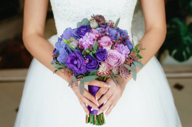 mor bir buket tutan gelin. düğün çiçekleri. yumuşak odak.