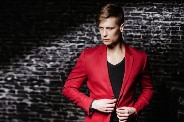 Adam kırmızı ceketli bir modeldir. Siyah bir arka plan güzel kahverengi saçlı adam.