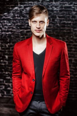 Adam kırmızı ceketli bir modeldir. Siyah bir arka plan güzel kahverengi saçlı adam.