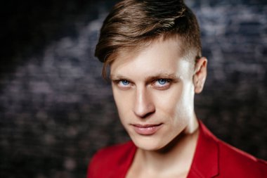 Adam kırmızı ceketli bir modeldir. Siyah bir arka plan güzel kahverengi saçlı adam.