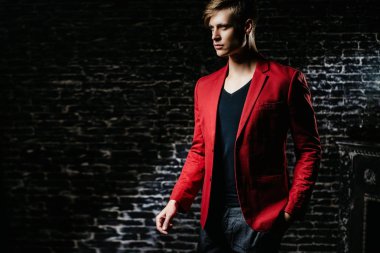 Adam kırmızı ceketli bir modeldir. Siyah bir arka plan güzel kahverengi saçlı adam.