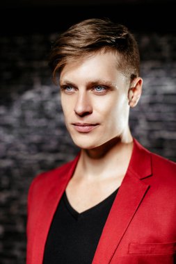 Adam kırmızı ceketli bir modeldir. Siyah bir arka plan güzel kahverengi saçlı adam.