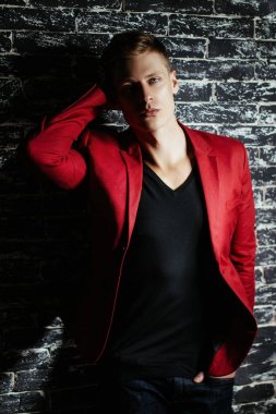 Adam kırmızı ceketli bir modeldir. Siyah bir arka plan güzel kahverengi saçlı adam.