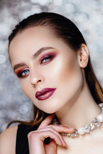 Portret z piękną dziewczyną z mokre włosy i makijaż fioletowy. Model z Biżuteria pozowanie na tle z bokeh. — Zdjęcie stockowe