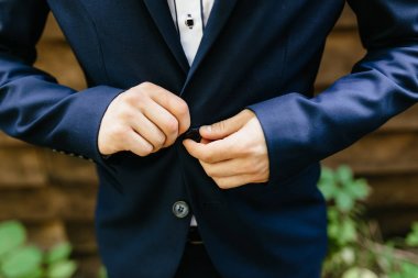 adam ceketinin takılır. Damat hazırlanıyor. Ceketini koyarak işadamı