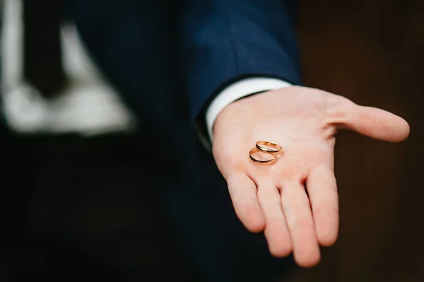 O noivo mantém alianças de casamento — Fotografia de Stock