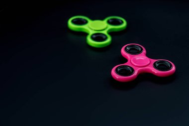 Pembe ve yeşil kıpır Spinner çalışması sırasında stres sürümü için siyah arka plan.
